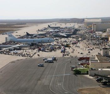 Military aircraft parked on the tarmac surrounded by people at air show at Edwards Air Force Base in Edwards, CA