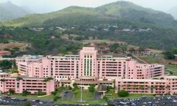 Aerial view of Tripler Medical Center Army Base in Honolulu, HI with a mountain in the background