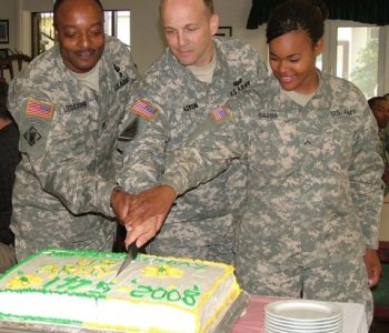 A group of people in military uniform cutting a birthday cake at USAG Darmstadt Army Base in Cooperstrasse, Germany