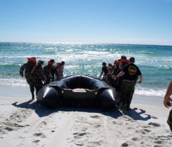 Special forces members launching a rubber boat onto the beach at NAS Panama City Navy Base in Panama City, FL