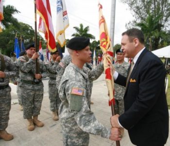 Army soldier and color guard receiving a flag from a civilian at  Fort Buchanan Army Base in Guaynabo, Puerto Rico