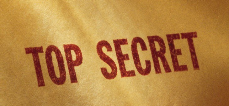 Close up image of antique paper with the words Top Secret stamped in red.