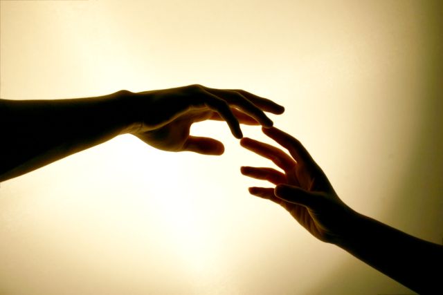 image of two hands reaching out to touch each other