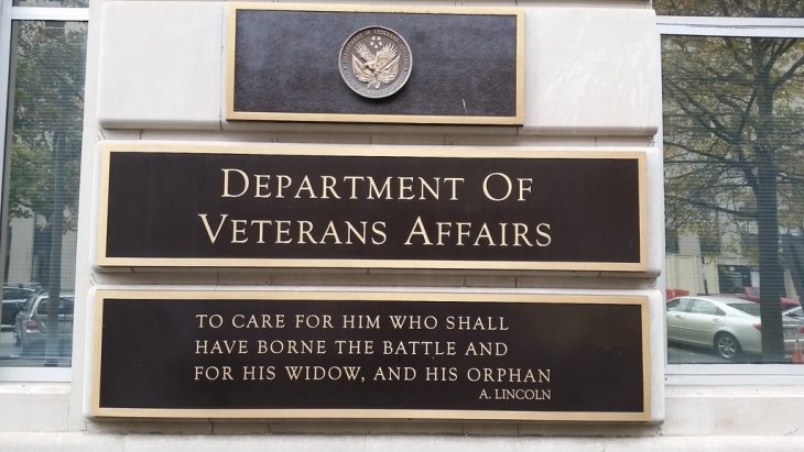 Image of the Department of Veterans Affairs logo and sign on the VA headquarters building, along with a quote from Abraham Lincoln