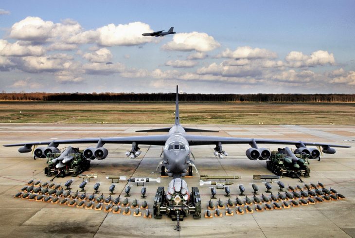 Image of B-52 bomber on tarmac with cluster bombs and other armaments on display